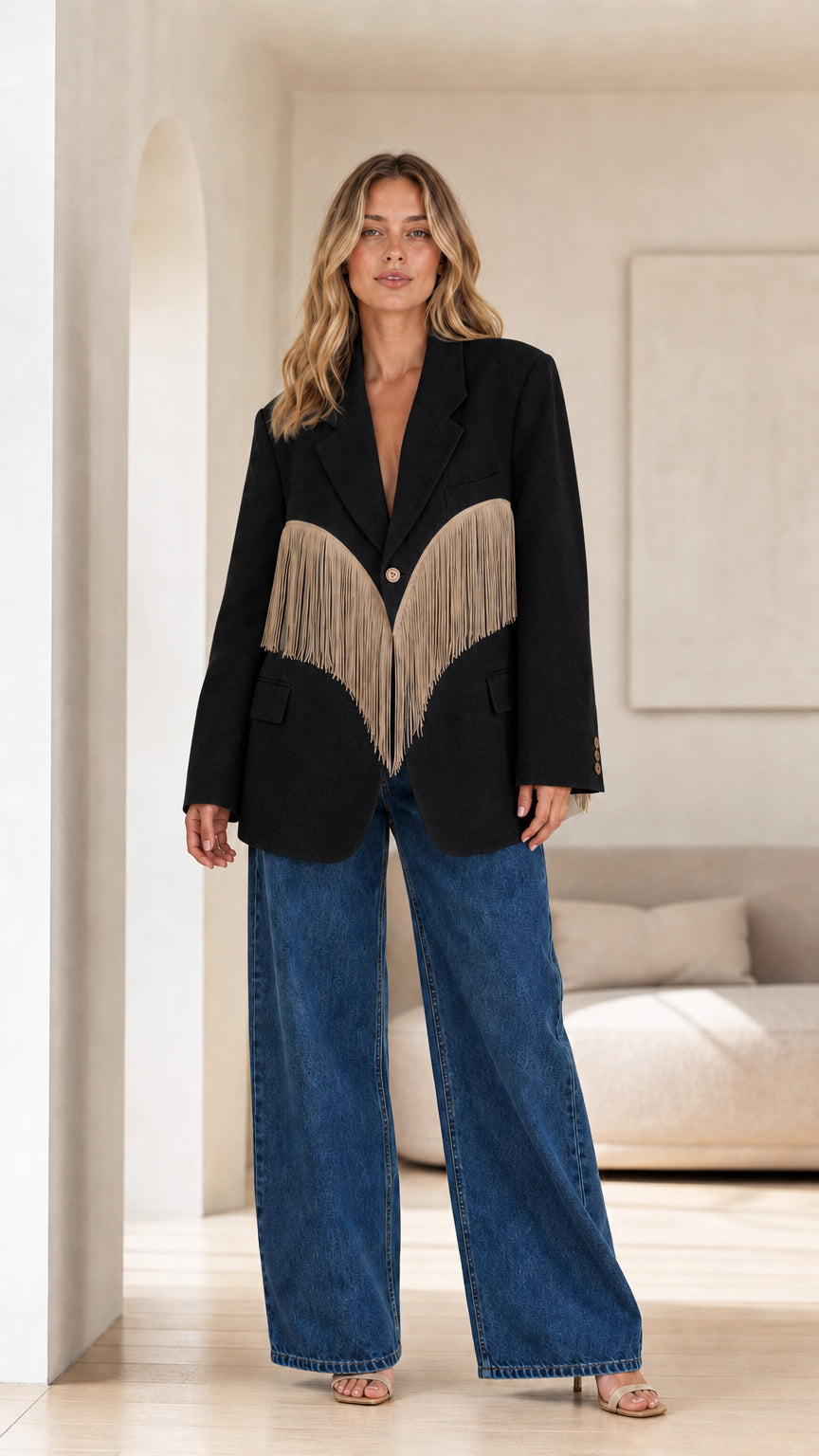 Model wearing Black tailored blazer with contrasting beige fringe trim and wide-leg jeans