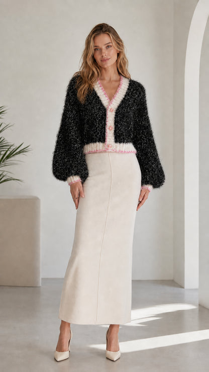 Model wearing black fuzzy knit cropped cardigan with contrast pink and white trim