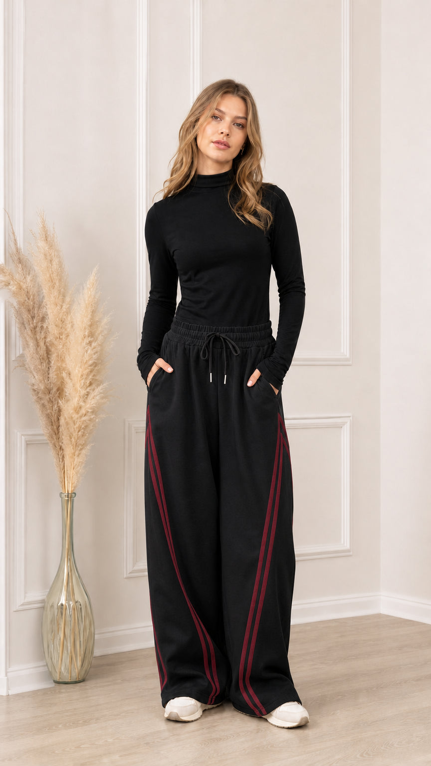 Full front view of black wide-leg sweatpants with burgundy side stripes