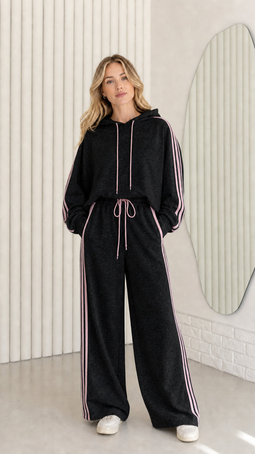 Woman wearing Black two-piece tracksuit set with contrast pink stripe accents