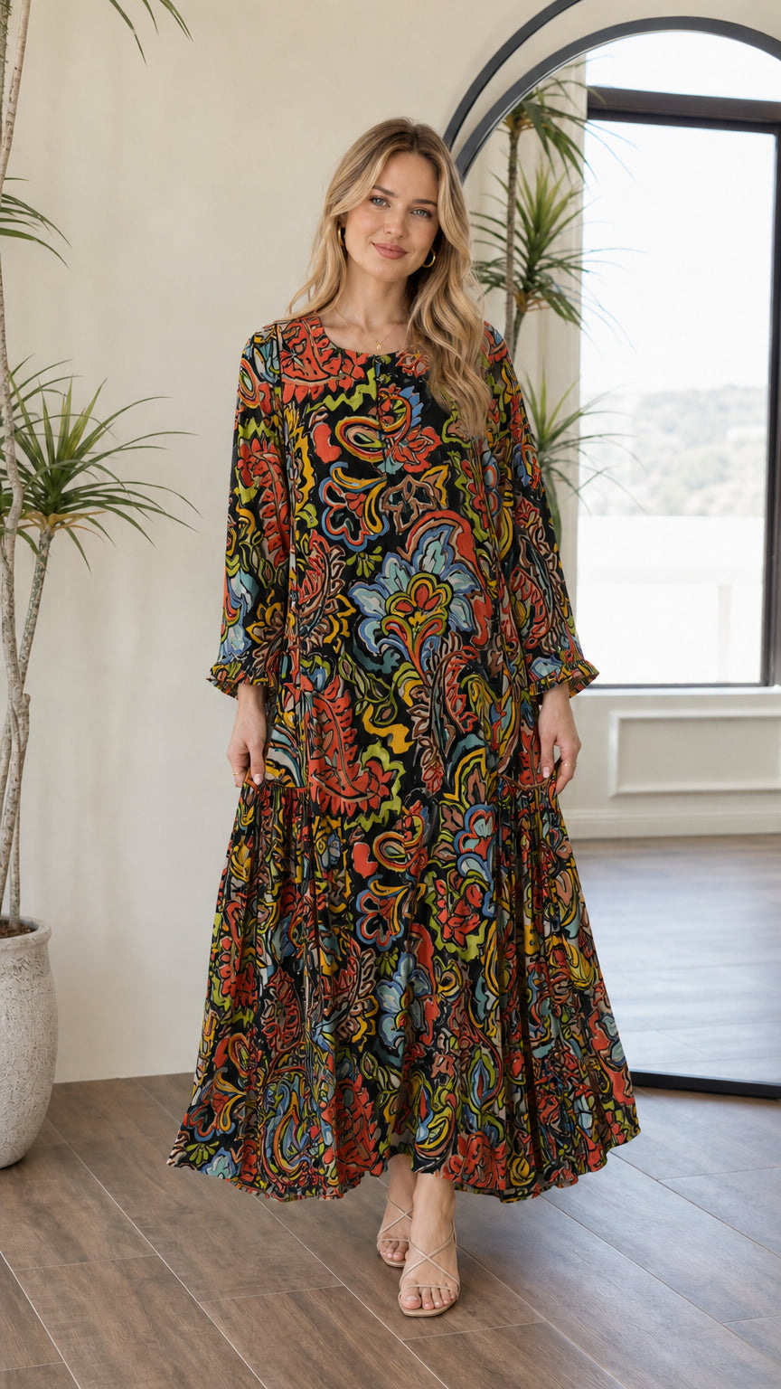 Front view of woman wearing black multi paisley long sleeve tiered maxi dress