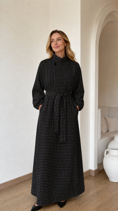 Front view of woman wearing Black grid check high neck belted maxi dress