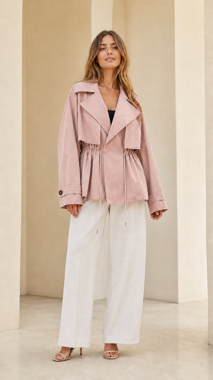 Front view of model wearing dusty pink short drawstring trench jacket