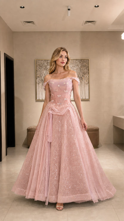 Model wearing blush pink glitter tulle ball gown with off-the-shoulder neckline