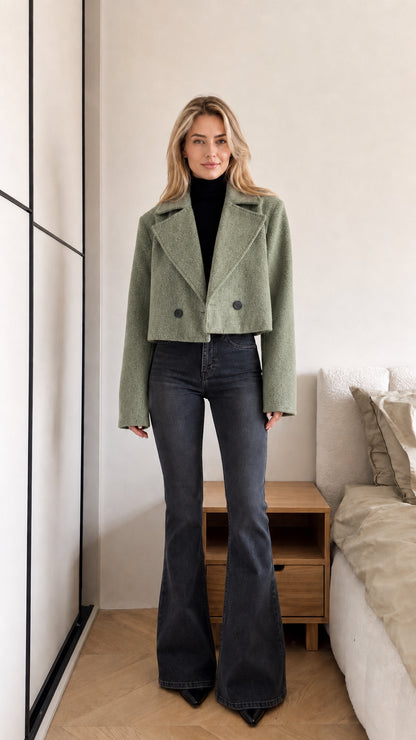 Model wearing sage green cropped double-breasted jacket with black underlayer