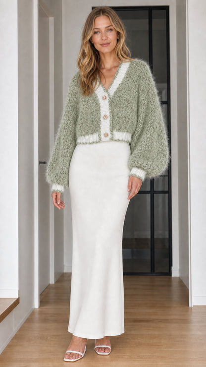 Model wearing sage green fuzzy knit cardigan sweater with white trim