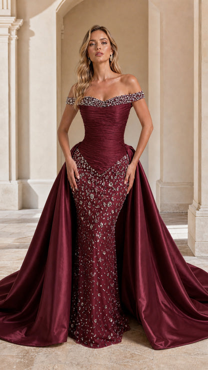 Model wearing Burgundy red off-the-shoulder beaded formal evening gown with overskirt