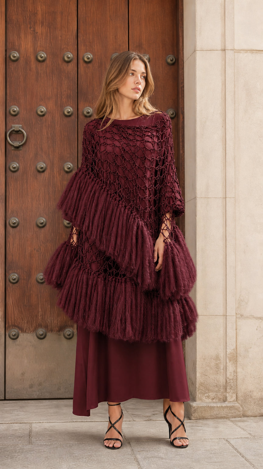 Front view of burgundy wine tiered fringe crochet poncho top styled with matching skirt