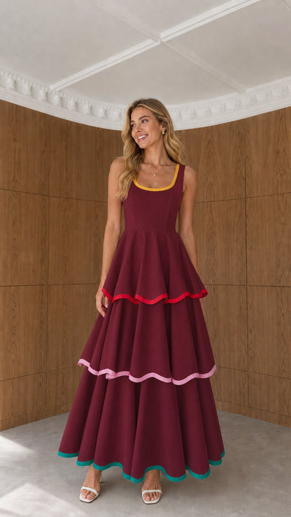 Model wearing burgundy red tiered maxi dress with colorful trims