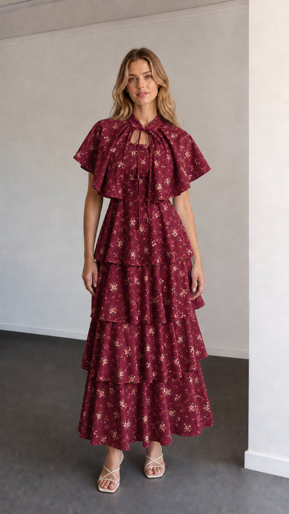 Full-length view of burgundy floral capelet tiered maxi dress