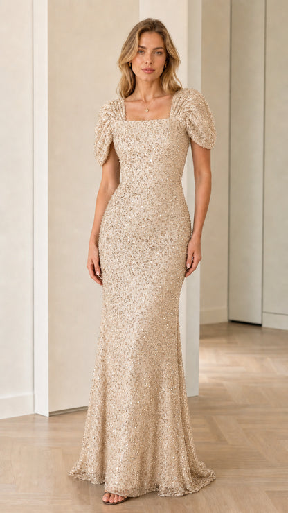 Front view of model wearing champagne gold sequin maxi dress