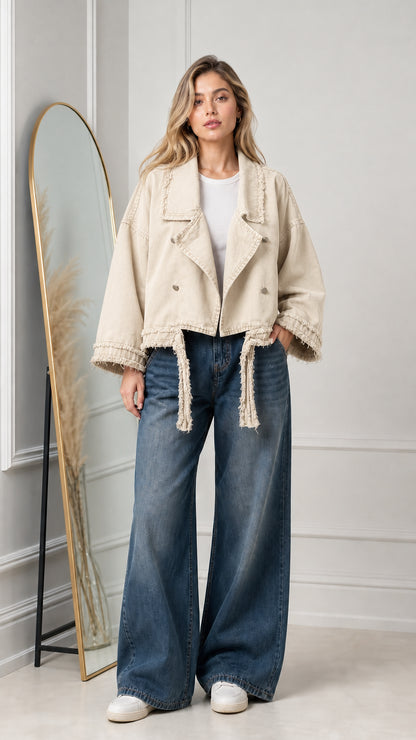 Model wearing beige cropped denim moto jacket with frayed accents